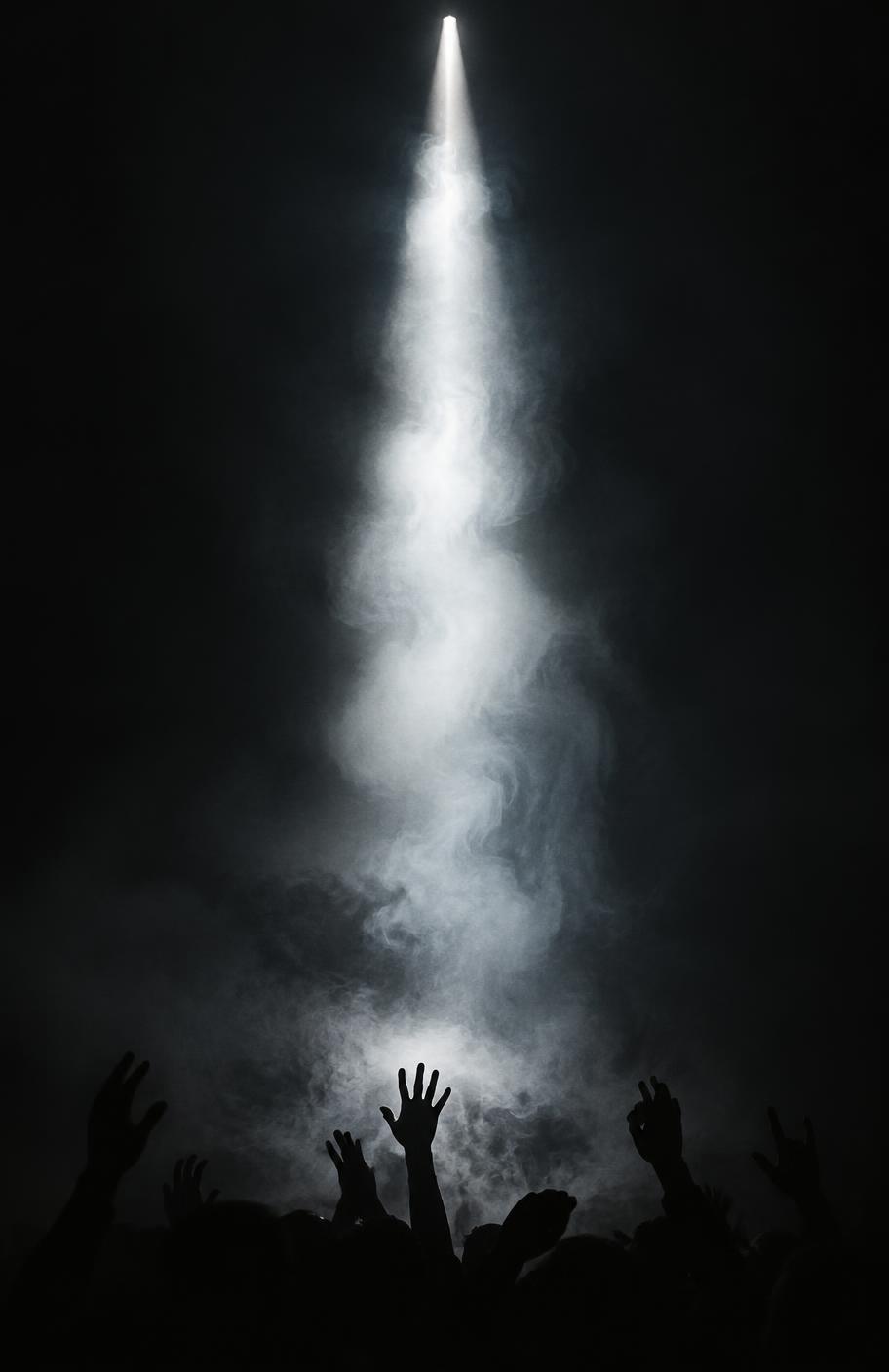 Haz de luz atravesando humo sobre el público